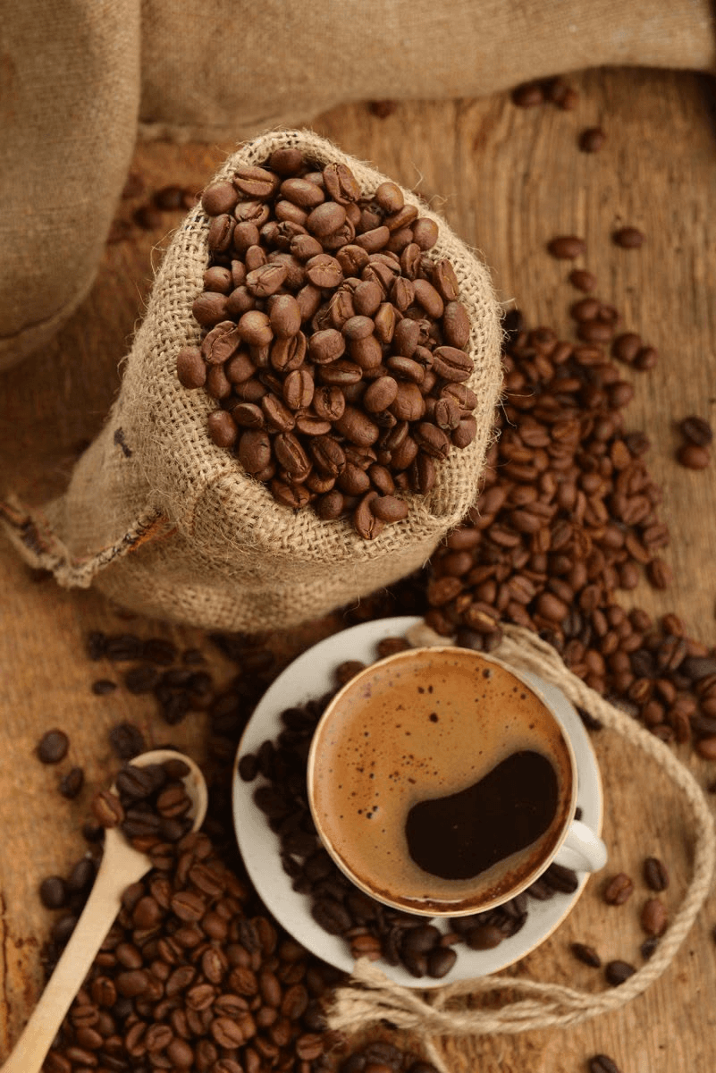 Roasted arabica beside a freshly brewed cup.